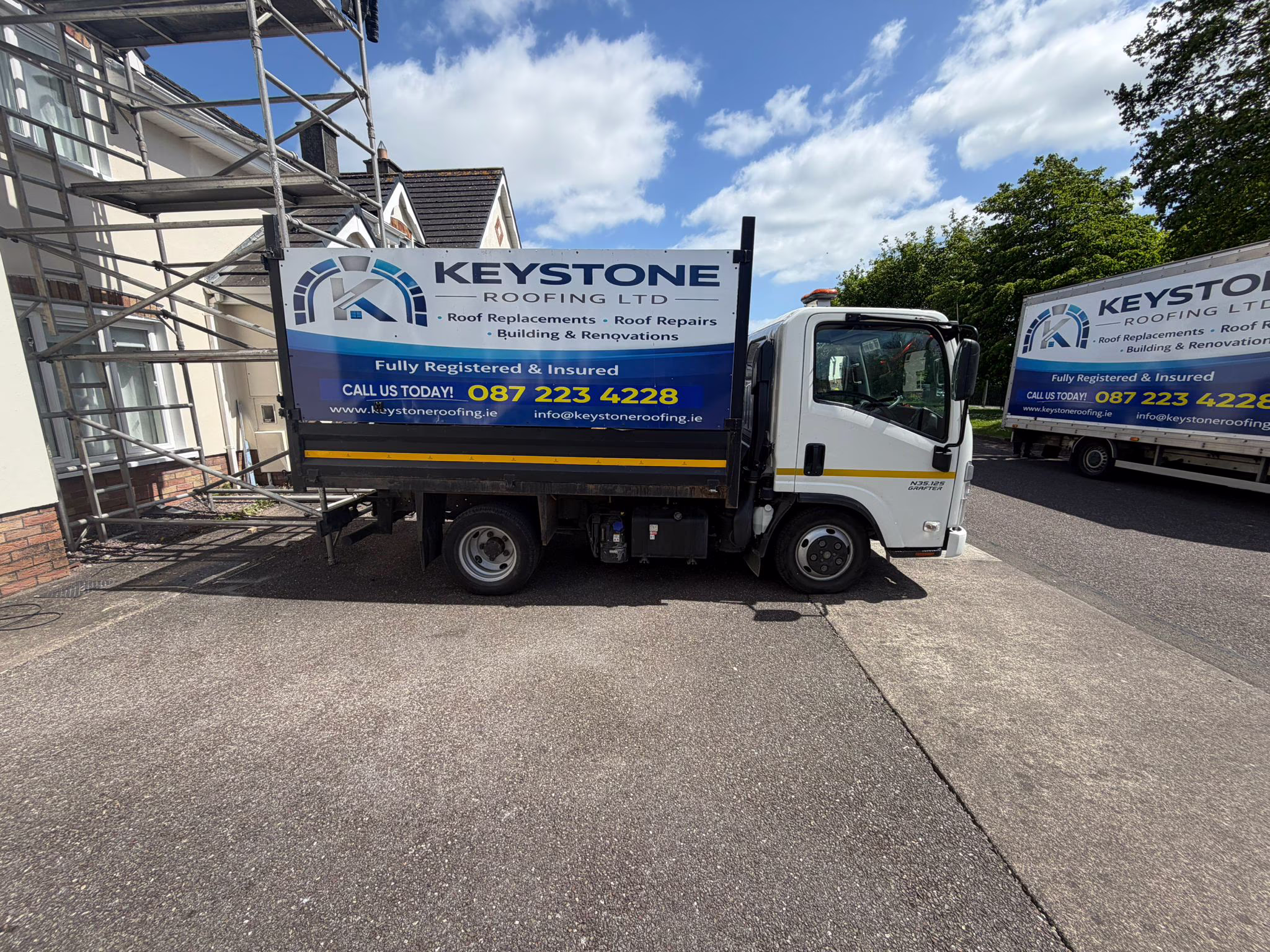 Keystone Roofing branded tipper truck parked at a Cork roof job with scaffolding